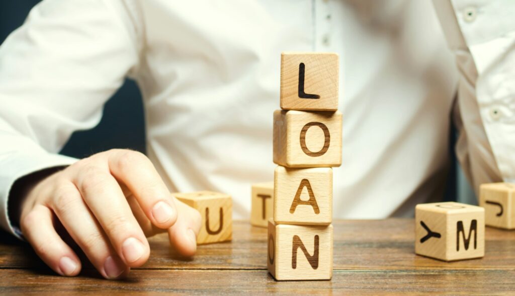 Wooden blocks with the word loan and businessman